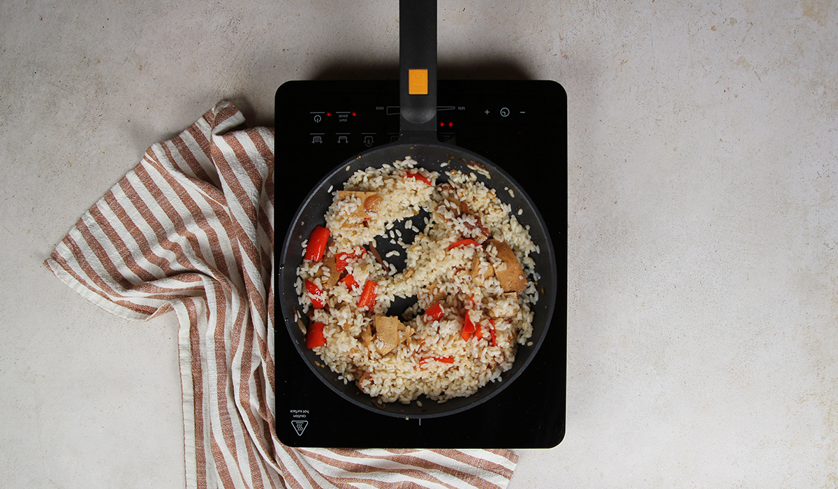 Añadir tofu a sartén en arroz con tofu