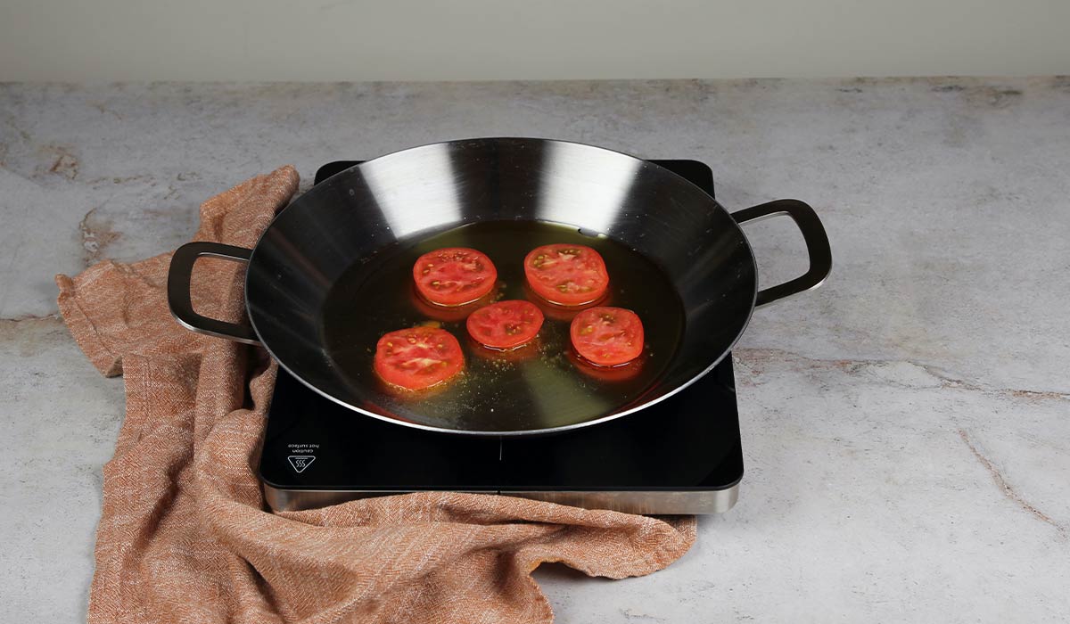 Sofreír tomates en Arroz al horno en paella