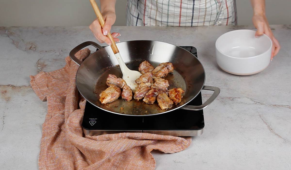 Sofreír las costillas para Arroz al horno en paella