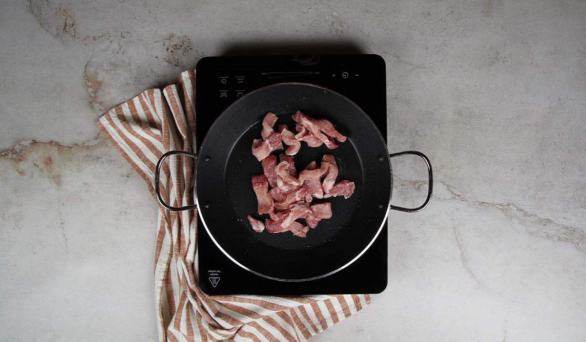 Sofreír carnes en Fideuá de carne de cerdo