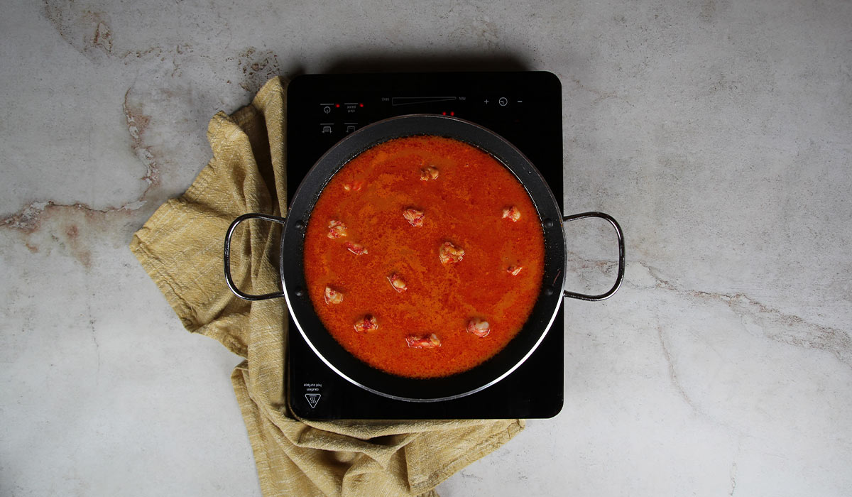 Añadir caldo y carabineros en Paella de Carabineros