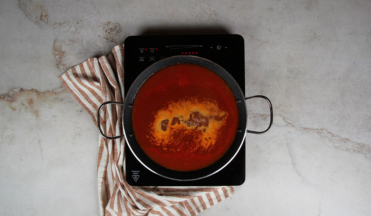 Añadir fideos y caldo a Fideuá de carne de cerdo