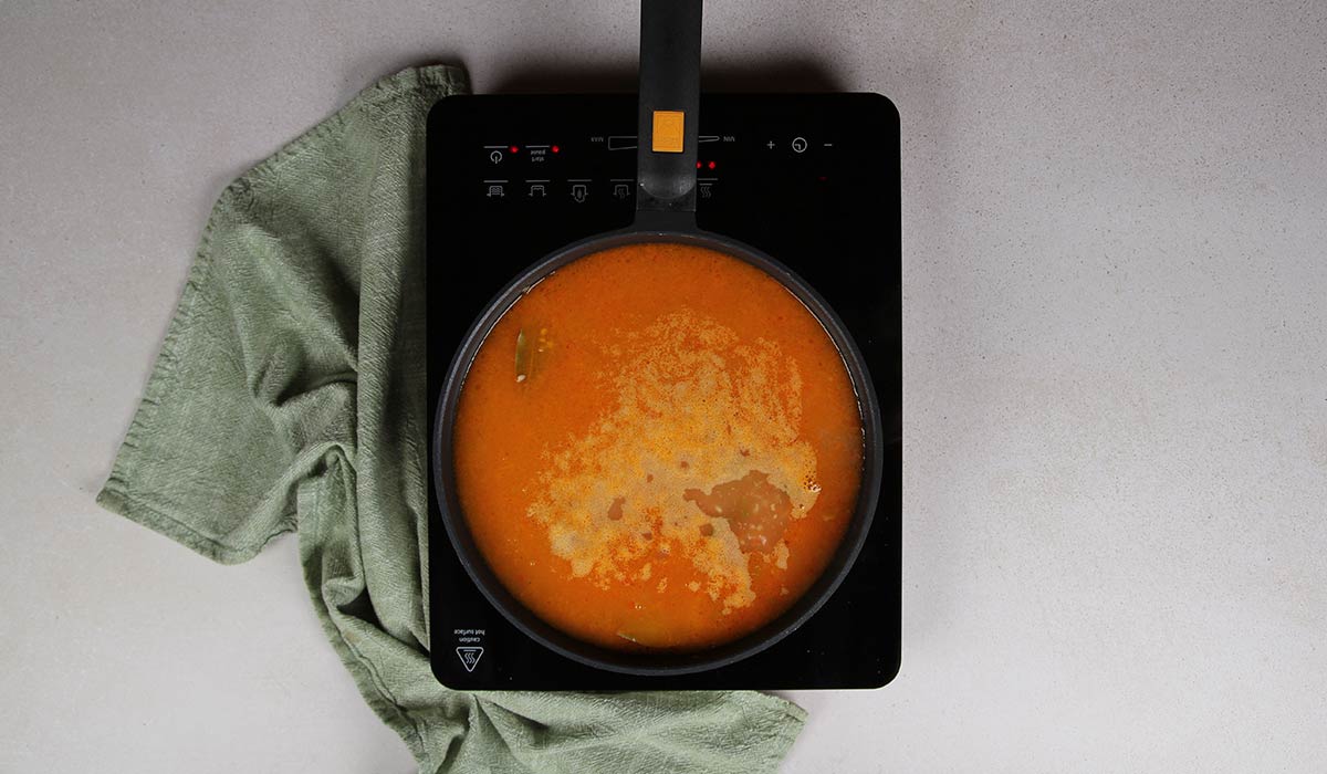 Incorporar caldo para Arroz con costillas y alcachofas