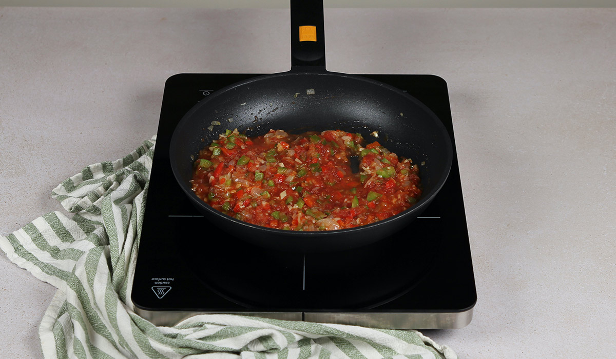 Añadir tomate a arroz con habas y alcachofas