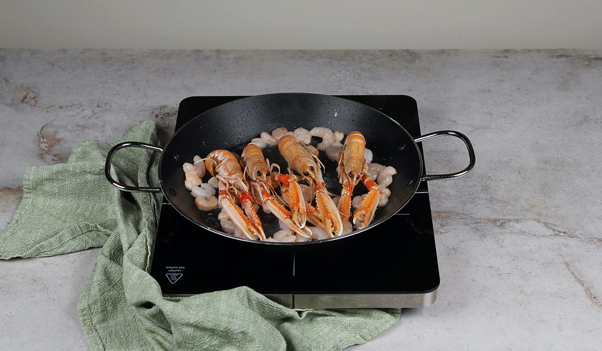 Cocinar gambas y cigalas en fideuá valenciana