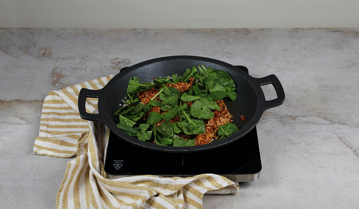 Incorporar espinacas en paella con boquerones y espinacas