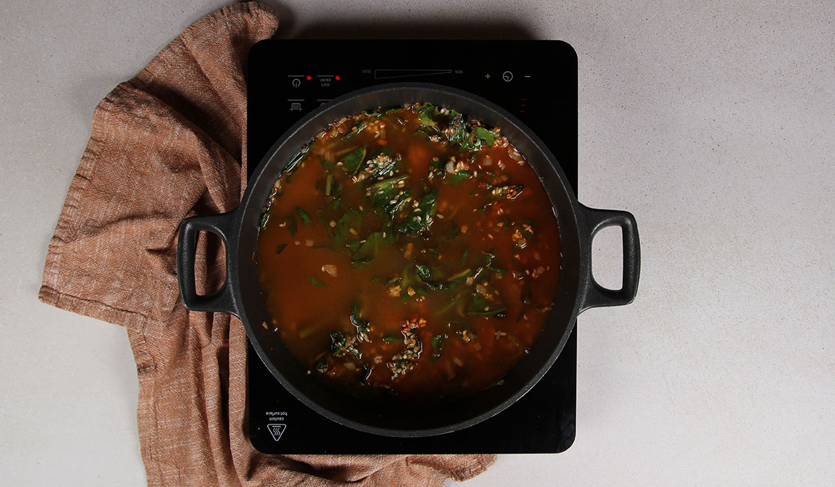 Incorporar caldo en arroz con acelgas y alubias