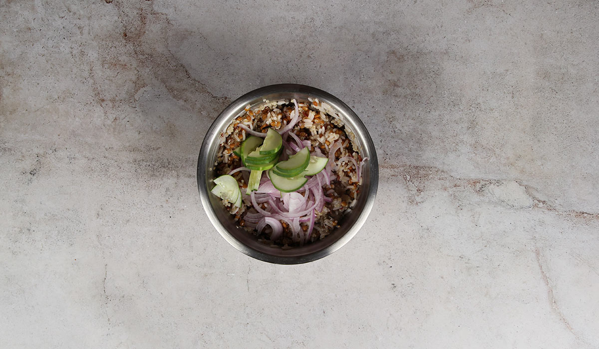 Mezcla de ingredientes en ensalada de lentejas y quinoa