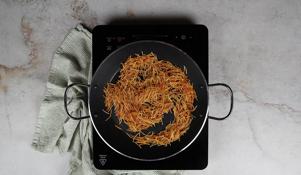 Tostar los fideos en fideuá a la marinera