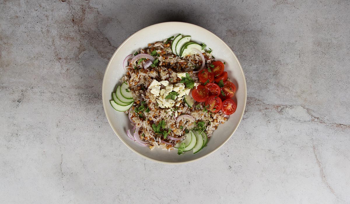 Añadir queso y vinagreta en ensalada de lentejas y quinoa