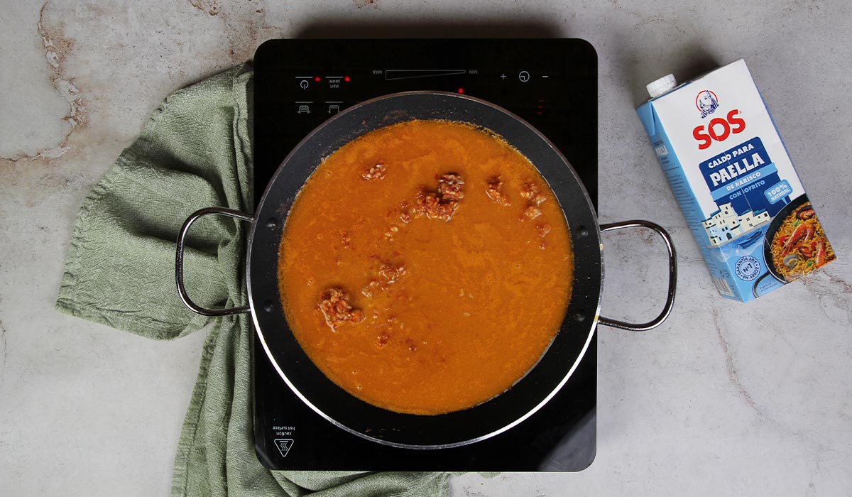 Añadir caldo y azafrán a Paella de bogavante