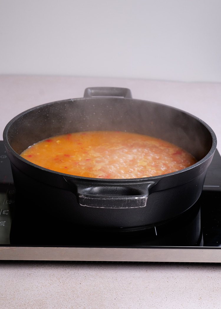 Añadir arroz y caldo para arroz con muslitos de pollo