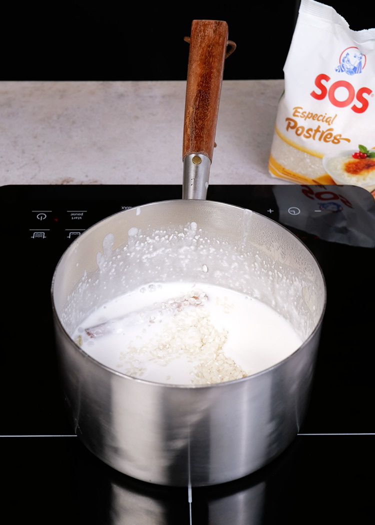 Cocinar arroz, leche con canela y carcadomo en arroz con leche de coco y mango