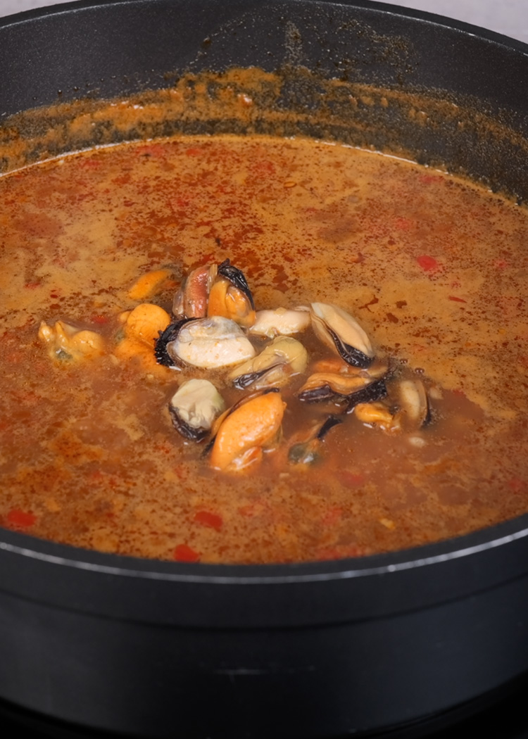 Reincorporar mejillones a arroz caldoso con mejillones