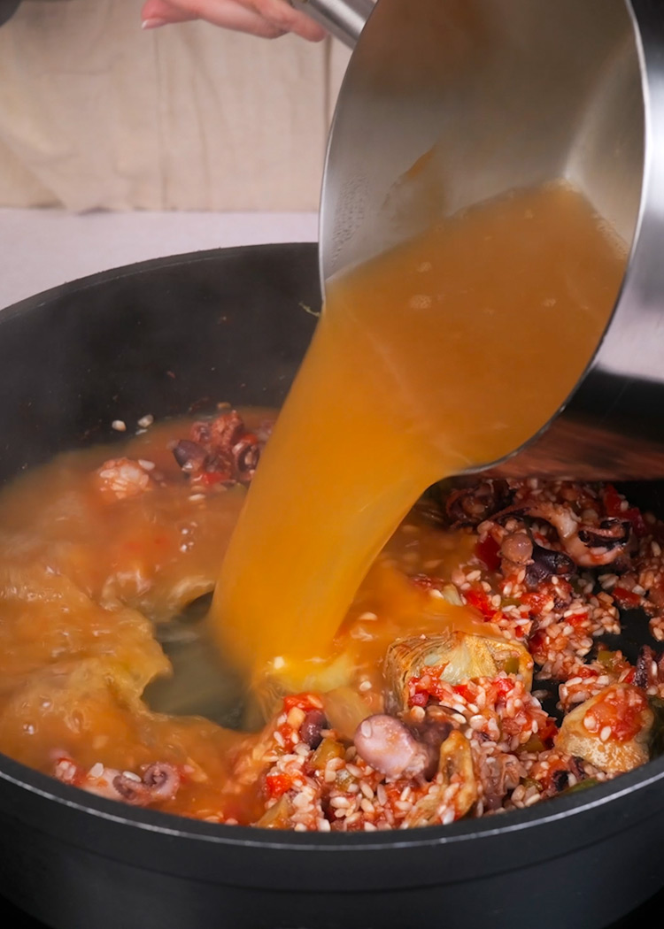 Verter caldo en arroz con pulpitos y alcachofas