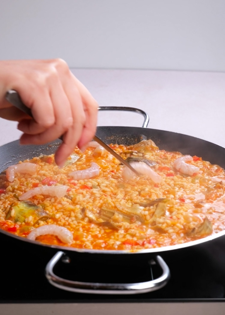 Colocar gambas en arroz con alcachofas y gambas