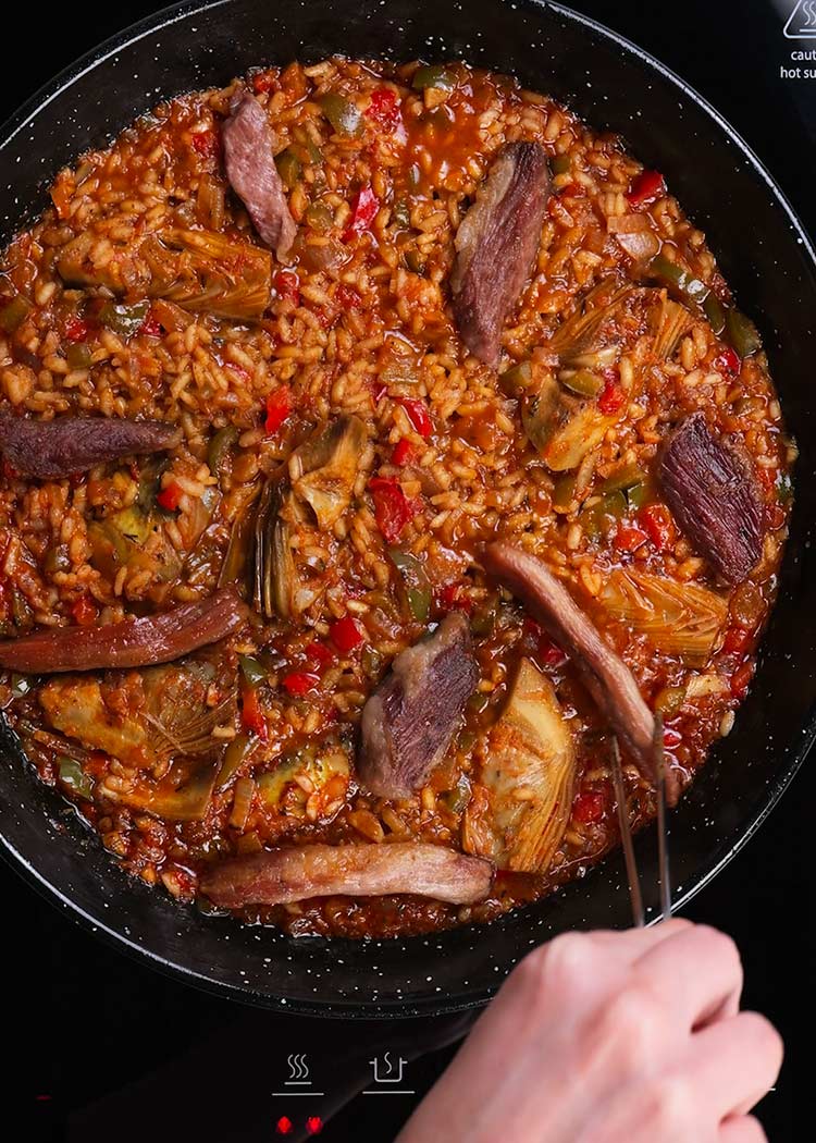 Reincorporar secreto a arroz con secreto y alcachofas