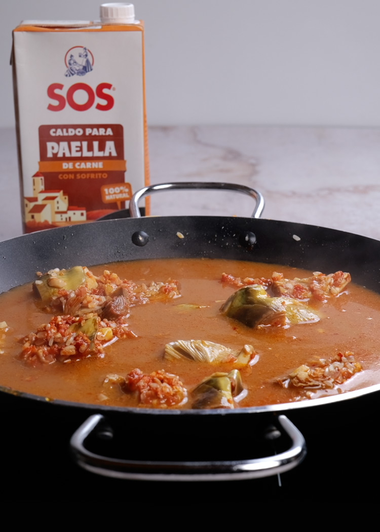 Verter caldo en paella de alcachofas