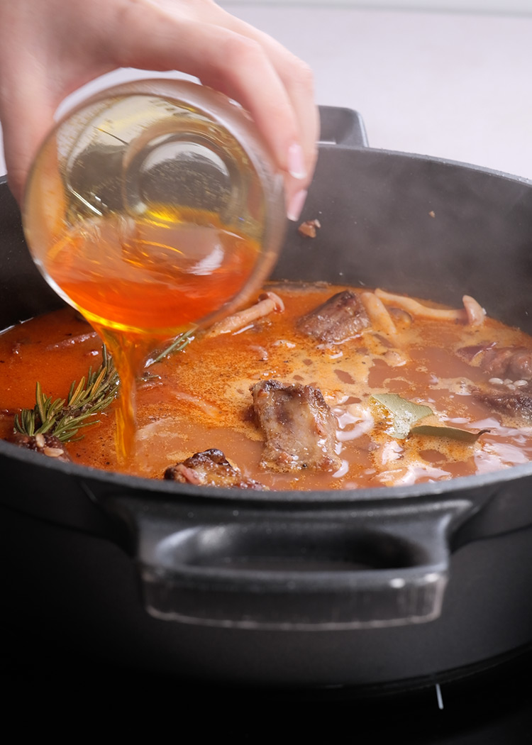 Caldo, especias y azafrán en arroz al horno con costillas