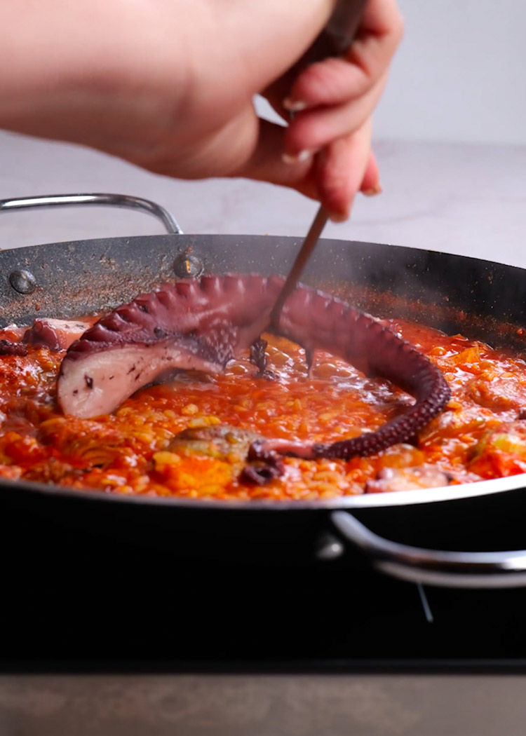 Añadir pulpo a paella de pulpo y alcachofas