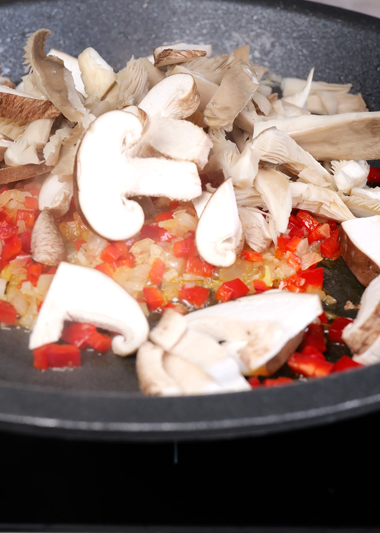 Incorporar setas y pimentón a arroz con costillas y setas